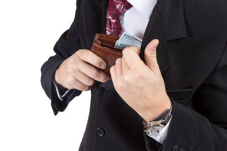 Businessman puts his purse full of money into the inner pocket of his jacket isolated on a white...
