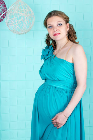 Portrait of pregnant woman in blue long dressの写真素材