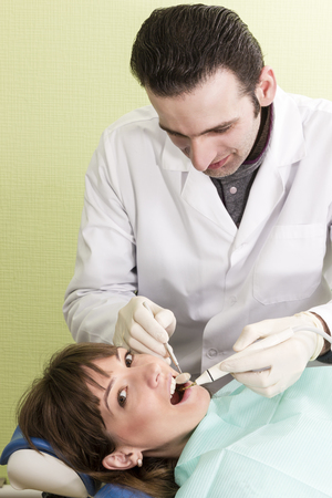 Portrait of dentist who treats teeth young woman patientの写真素材