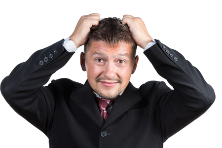 Businessman in suit and tie expressing negative emotions tearing at her hair isolated on white backgroundの写真素材