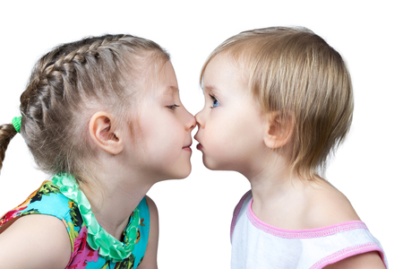 Two children look at each other and touched noses isolated on white backgroundの写真素材