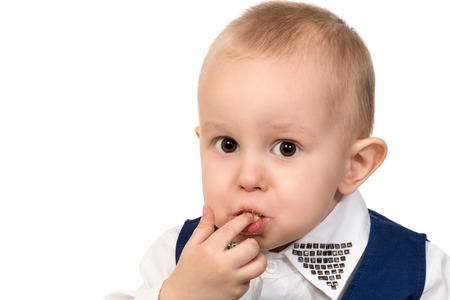 Close-up portrait of a little boy a mouth full of of crumbs and stained lips isolated on white backgroundの写真素材