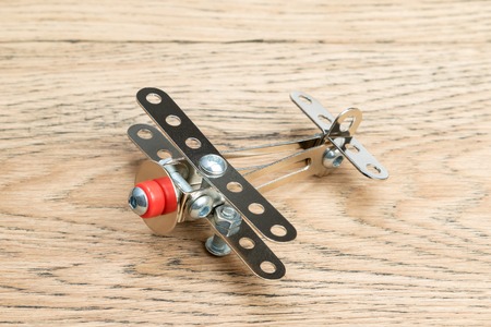Children plane made of iron constructor on an old wooden boardの写真素材