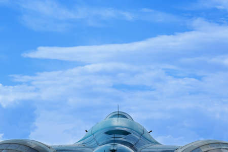 Military jet plane view of the tail close-up on a background of blue sky with cloudsの写真素材