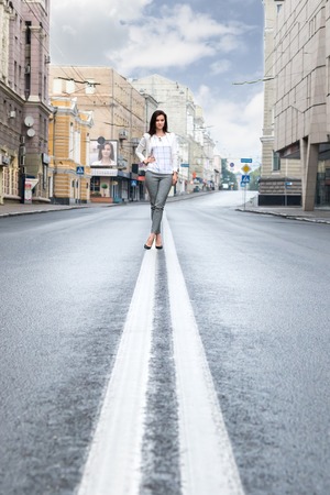Portrait of a beautiful business woman on a double lane on the street empty cityの写真素材