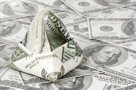 Basket origami folded from dollar bills on dollars background stacked on the tableの写真素材