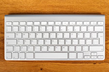 New wireless computer keyboard on a wooden table, close-upの写真素材