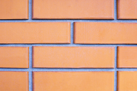 Brick wall close-up of orange bricks with smooth cement-sand seamの写真素材