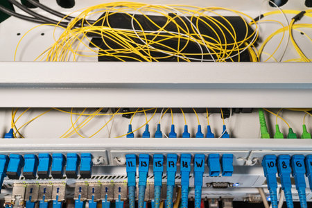 Rack with routers with open top cover and wires inside