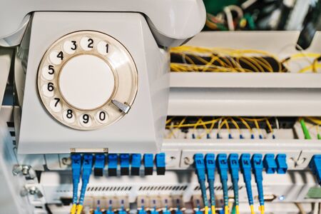 Conceptual photo - old retro phone on a rack with internet routersの写真素材