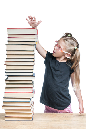 Schoolgirl showing her hand the size of a stack of books to explore, isolated on a white backgroundの写真素材