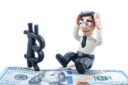 Conceptual photography. Plasticine businessman worries about bitcoin ousting dollar isolated on white backgroundの写真素材