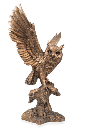 A bronze statuette of a flying owl with flapping wings isolated on white backgroundの写真素材
