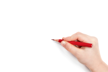 Child hand holding a red pencil and getting ready to draw, isolated on a white backgroundの写真素材
