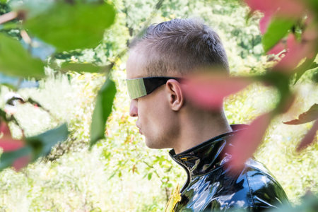 Detective with glasses and a cloak goes through the leaves in the forest