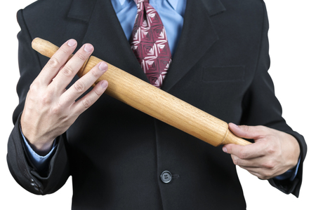 Businessman in suit with a tie is holding a wooden rolling pin, close-up, isolated on a white backgroundの写真素材