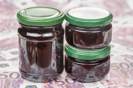 Jars with raspberry jam on the money with face value of five hundred euroの写真素材