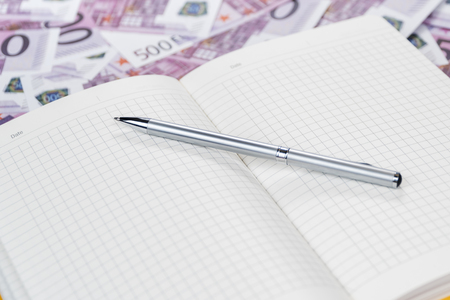 empty diary in a cage with a pen on euro moneyの写真素材