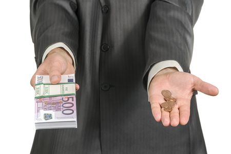businessman offers money - in one hand a bundle of paper euro and in the other a few euro cents, isolated on a white backgroundの写真素材