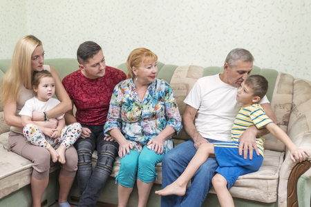 Grandfather plays with his grandson, telling him a secret, whispering in his earの写真素材
