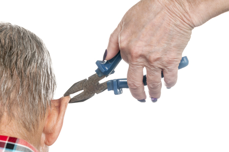 Female hand holding a pair of pliers for a man ear, close-up, isolated on a white backgroundの写真素材