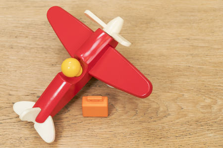 small suitcase and toy plane on the old wooden tableの写真素材