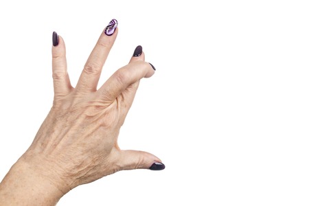 crossed index and middle fingers of an old woman isolated on white backgroundの写真素材