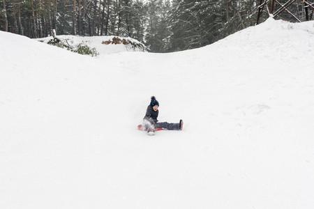 child is moving down a hill on a red ice-boatの写真素材
