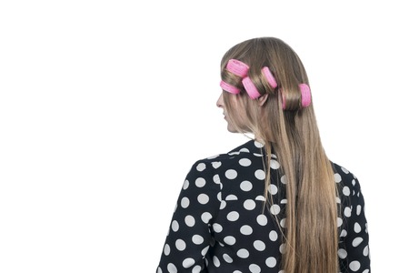 Portrait of a woman in polka dot shirt with curlers from the back, isolated on white backgroundの写真素材