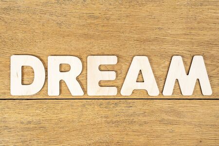 Word - dream, laid out in wooden letters on an old wooden tableの写真素材