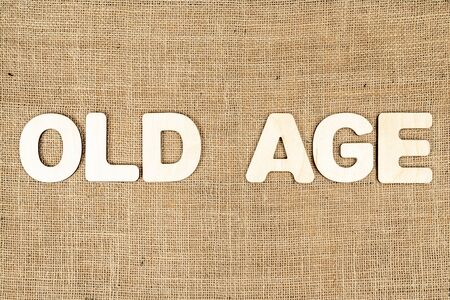 phrase - old age is laid out in wooden letters on the old brown sackingの写真素材
