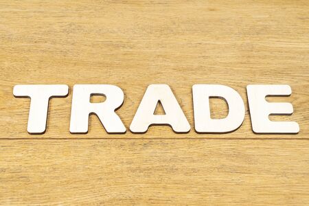 Word - trade, laid out in wooden letters on an old wooden tableの写真素材