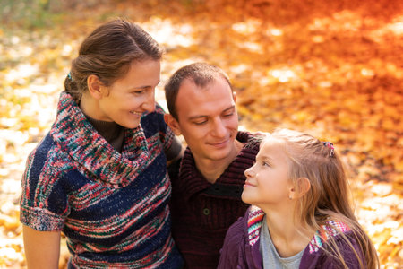 Portrait mother and father lovingly look at their daughter