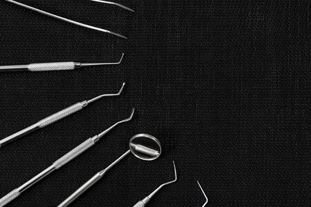 several dental instruments lying sideways on a black backgroundの写真素材