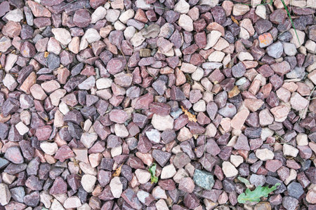 mound of rubble gray white and brown color with green leaves and debris as background