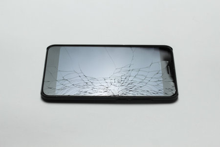 Mobile smartphone with broken screen on white background.の写真素材