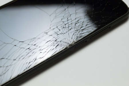 Accidentally cracked, damaged smartphone LCD screen isolated on white background.の写真素材