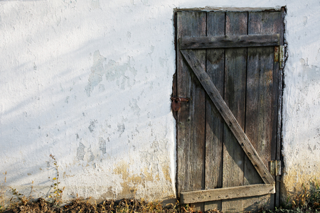 Old wooden door in an old stone wall with a castleの写真素材