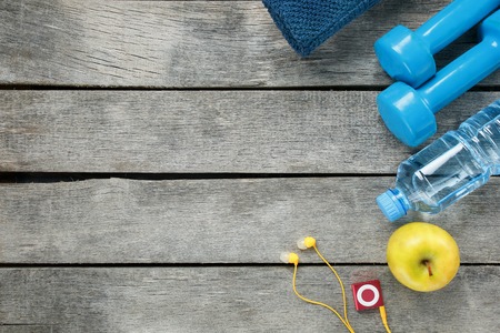 sports equipment on a gray, wooden background, dumbbells, apple water in a bottle, playerの写真素材