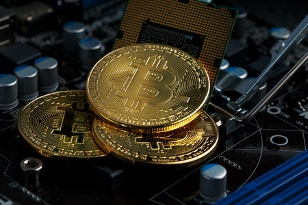 Golden Bitcoin Cryptocurrency on a computer board. Macro shooting. The concept of cryptocurrency with coins, bitcoin on a computer processor. New cryptocurrency, three coins Bitcoin and computer duties.の写真素材