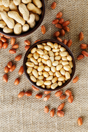 Peanuts in the shell and peeled closeup in a cup