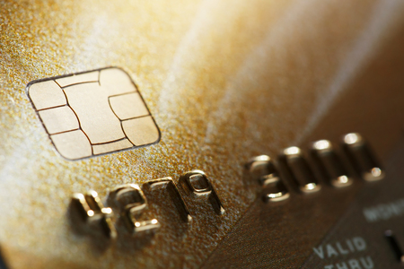 Gold credit card with micro chip selective focus. Macro shooting with a credit card. Selective focus microchip on paying by credit card or debit card for background. contactless paymentsの写真素材