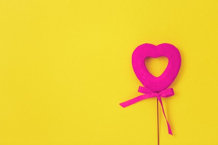 Pink heart on a yellow background. Red heart with a bow. Love. Valentine's Day.の写真素材