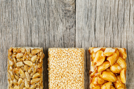 Assorted kozinaki, on the old vintage background. Country style. Delicious sweets from the seeds of sunflower, sesame and peanuts drenched in shiny glaze. Macro close upの写真素材