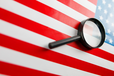 The American flag is viewed through a magnifying glass. Spies and surveillance USA concept. Control of the state of the United States. War Terrorism Theft Conceptの写真素材