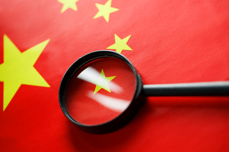 The flag of the CHINESE PEOPLE'S REPUBLIC is looking through a magnifying glass. The study of the history and culture of a large country and the people of China. The concept of studying the geography, customsの写真素材