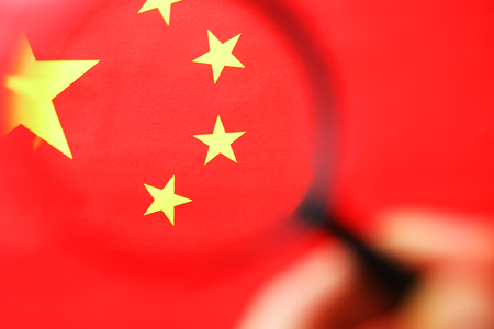 The flag of the CHINESE PEOPLE'S REPUBLIC is looking through a magnifying glass. The study of the history and culture of a large country and the people of China. The concept of studying the geography, customsの写真素材