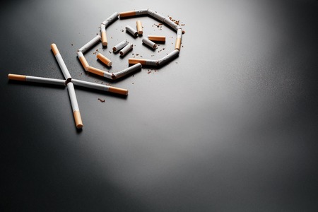 Skull from cigarettes on a black background. The concept of smoking kills. Toward the concept of smoking as a deadly habit, nicotine poisons, cancer from smoking, illness, quit smoking. Copy spaceの写真素材