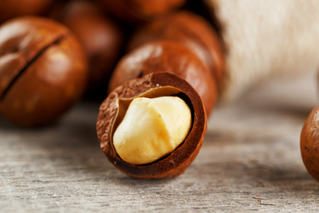 Macadamia nut on a wooden table in a bag, closeup, top view. Healthy productの写真素材