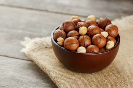 Macadamia nut on wooden background with vintage cloth, concept of superfoods and healthy food. Overhead costs or top view shotの写真素材